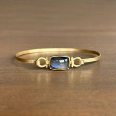 A mercurial labradorite is the centerpiece of this splendid gold bracelet. 18k yellow gold Labradorite, 6.92ct, 13mm x 9mm (1/2" x 3/8") Bracelet circumference is 7.32” Rectangular Gemstone Bracelet In Yellow Gold, Elegant Gold Bracelet With Oval Cabochon, Rectangular Yellow Gold Bracelet With Gemstone, Gold Metal Bracelet With Cabochon, Luxury Gold Bracelet With Oval Cabochon, Elegant Gold Labradorite Bracelets, Oval Cabochon Labradorite Jewelry, Newport Rhode Island, Newport Ri