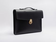 Mens leather briefcase in a classic yet modern style, to treasure for years to come. Brass lock closure, top handle, envelope style flap.Elegant, rich Italian full grain veg tanned leather (Buttero) exterior, with optional lined interior. Luxury designer quality, handmade in the US with the finest materials sourced from Italy and France. Hand stitched and hand painted edges.Buttero leather has a smooth finish with a slight sheen, and will patina beautifully with use and time, creating a bag uniq Timeless Rectangular Briefcase For Business, Business Bags With Coin Pocket And Rectangular Shape, Timeless Rectangular Briefcase With Palladium Hardware, Timeless Business Briefcase, Elegant Business Bags With Coin Pocket, Luxury Briefcase With Case Included For Business Trips, Timeless Formal Rectangular Briefcase, Classic Briefcase With Smooth Grain For Business, Classic Leather Briefcase