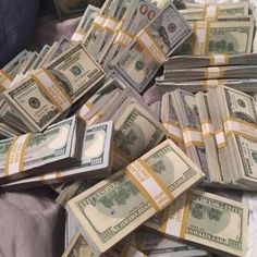 a pile of money sitting on top of a bed