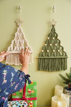 a person holding a small piece of string art next to a christmas tree ornament