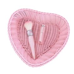 a pink heart shaped basket with two brushes inside