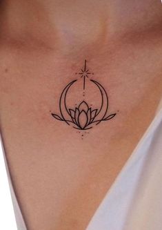 a woman's chest with a lotus tattoo on her left side, and a cross in the middle