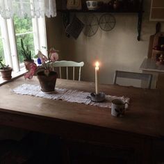 a wooden table topped with a candle and potted plants