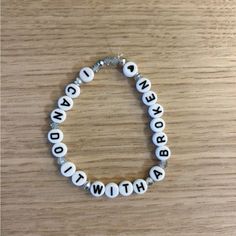 a white beaded bracelet with the words brooklyn, new york and broadway written on it