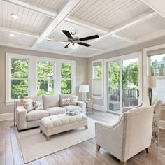 a living room filled with furniture and lots of windows