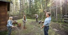 a group of people that are standing in the grass near a fence and some trees