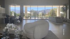 a living room filled with furniture and lots of glass doors leading to a patio area