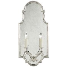 a wall mounted mirror with two candles on it's sides and one light in the middle