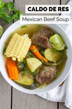 a white bowl filled with meat, vegetables and corn on top of a wooden table