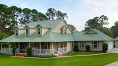 a large house with a green roof and two car garages