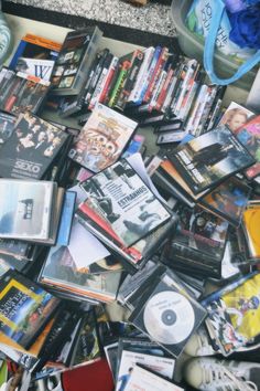 there are many dvds and cds on the floor next to each other, all piled up together