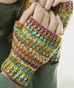 a close up of a person wearing a knitted mitt with one hand on the other