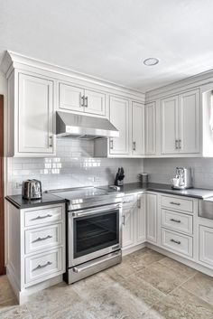 a kitchen with white cabinets and stainless steel appliances