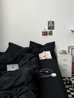 an unmade bed in a bedroom with black and white checkerboard flooring