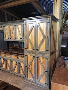 a large wooden cabinet with sliding doors on the front and back sides in a room