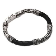 Naga chain of sterling silver is alternated with dark brown braided leather encircling the wrist in this Balinese bracelet. Designed for the modern man the bracelet features a bold design by Cahya Krisna who gives it a regal aesthetic. This accessory closes with a sterling box clasp. Classic Engraved Silver Leather Bracelet, Black Oxidized Finish Bracelet Jewelry, Adjustable Black Oxidized Bracelet, Black Leather Band Bracelet, Modern Adjustable Black Sterling Silver Bracelet, Classic Black Engraved Bracelets, Classic Black Leather Bracelet Engraved, Classic Black Engraved Leather Bracelet, Black Leather Bracelets With Sterling Silver Clasp