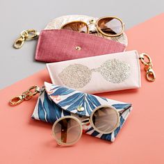 three small purses with sunglasses on top of them