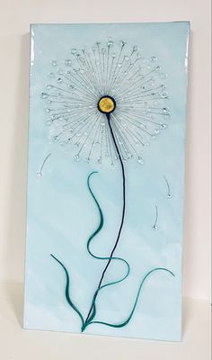 a blue painting with a dandelion in the center and water droplets on it