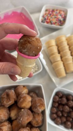 a person holding an ice cream cone in front of various desserts and candies