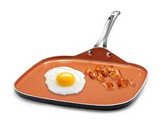 an orange pan with bacon and egg on it, sitting in front of a white background