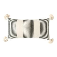 a black and white striped pillow with tassels on the front, along with two small pom - poms