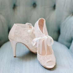 a pair of white shoes sitting on top of a blue couch