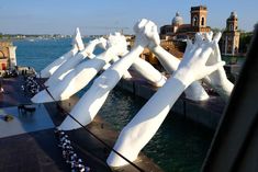 large white sculptures on the side of a body of water