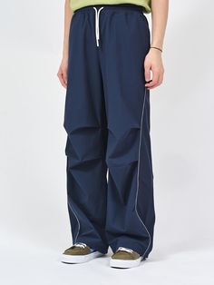 These are semi-wide fit curved piping pants made of nylon spandex ribstop fabric for a comfortable fit. It is accentuated with a reflective piping on the curved line from the waistline to the hem, and a three-dimensional silhouette is added with the tuck detail at the knee. - Semi-wide fit- Piping detail- Adjustable string on hem- Spoty mood Piping Pants, Blue Pants Men, Navy Blue Pants, Curves Workout, Track Pants, Three Dimensional, Piping, The Knee, Navy And White