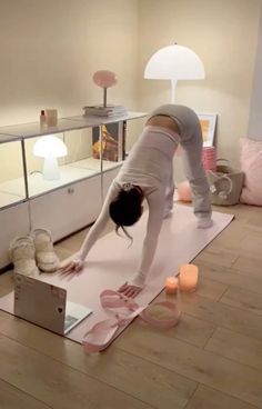 a woman is doing yoga in her living room