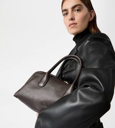 Characterized by maxi zip pulls, straps that elegantly cover the zip when closed, Tod's Darsena is defined by essential and feminine lines. Featuring characteristic tubular handles, it comes with the Tod's logo stamped on the front and a wrapped side padlock, a sophisticated distinctive trait. Here in fine natural-grained calfskin leather, this is a model with a distinctly urban nature, named after the city of Milan. Hermes Bag With Engraved Zipper Pull For Everyday Use, Luxury Fall Bags With Zipper Closure, Elegant Bags With Zipper Closure For Fall, Formal Calf Leather Bag With Zipper Closure, Elegant Calf Leather Bag With Zipper Closure, Elegant Calf Leather Bag For Fall, Evening Calf Leather Bag With Zipper Closure, Elegant Calf Leather Shoulder Bag With Zipper Closure, Most Expensive Bag