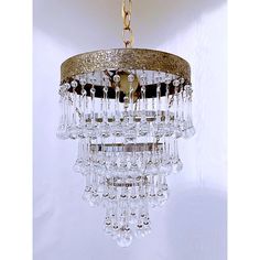 a chandelier hanging from the ceiling with lots of crystal beads on it's sides