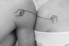 black and white photo of two women's butts with small tattoos on them