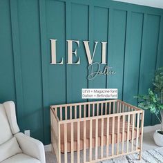 a baby's room with a crib, chair and wall name on it