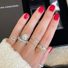 a woman's hand with four different rings on it