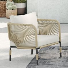 a white chair sitting on top of a rug next to a potted cacti