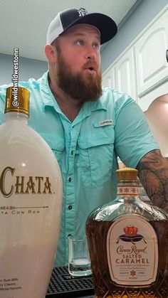 a man standing next to two bottles of liquor