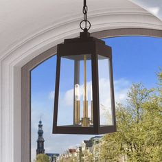 a lantern hanging from the side of a door in front of a window with trees outside