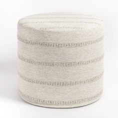 a white and grey round ottoman with stripes on the top, sitting in front of a white background