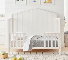 a child's bedroom with white furniture and pictures on the wall