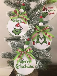 christmas ornaments hanging from the top of a tree with green and red ribbon on them