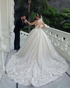 a bride and groom standing on a balcony