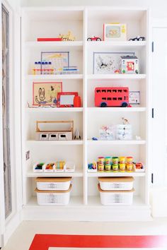 a white bookcase filled with lots of toys