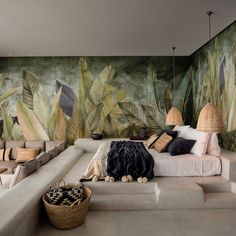 a large bed sitting in the middle of a living room next to a wall mural