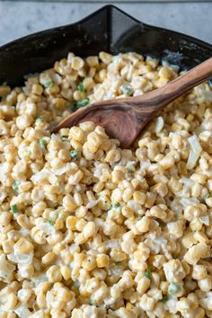 macaroni and cheese in a skillet with a wooden spoon