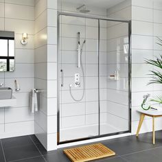 a white tiled bathroom with a walk in shower