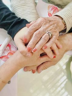 an older woman holding the hand of a younger woman with her hands on top of each other