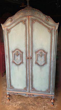 an antique armoire is painted blue and gold