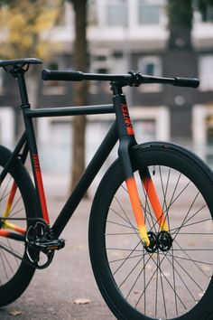 an orange and black bike is parked on the street