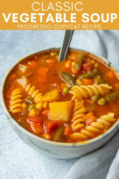 a bowl of vegetable soup with pasta and vegetables in it on a white table cloth