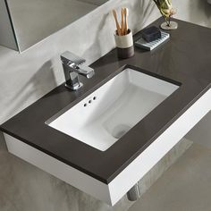 a bathroom sink sitting under a mirror next to a counter top with a phone on it